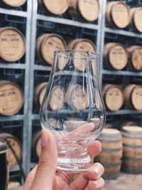 Close-up of hand holding drinking glass at brewery