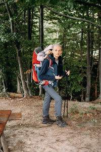 Side view of man standing in forest