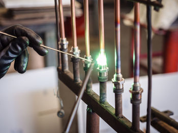 Cropped welder soldering metal at workshop