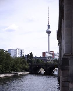 View of communications tower in city against sky