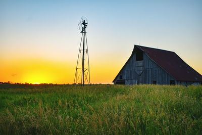 House on field against sky during sunset