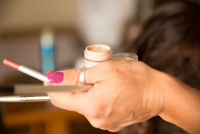 Cropped image of hand holding beauty product