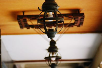 Low angle view of illuminated light bulb hanging on wall