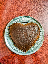 Home made chocolate cake in heart shape with all its unrefined edges and uneven surface