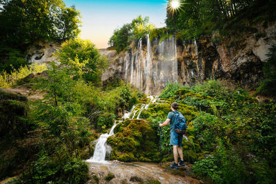 Hiker by waterfall in summer