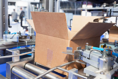 Close-up of cardboard box on conveyor belt in factory