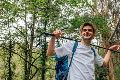 Portrait of smiling man holding umbrella in forest