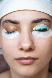 The master combs the eyelashes of a woman with a fish applicator. 