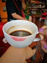 Low section of people holding drink on table