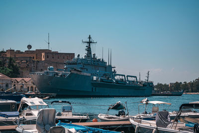 Boats moored at harbor against sky