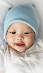 Cute baby girl looking away while lying on bed