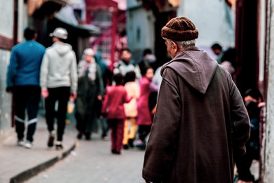 Rear view of people walking on street