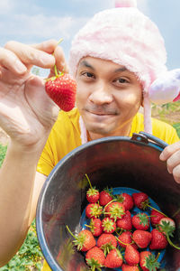 Portrait of smiling woman holding fruits