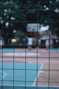 Defocused image of people seen through fence