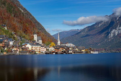 Town by sea and mountains against sky