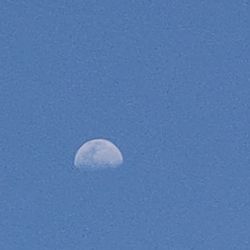 Low angle view of moon against blue sky