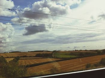 View of rural landscape against cloudy sky