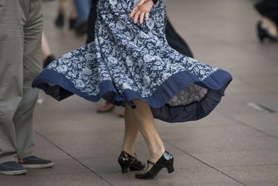 Low section of woman dancing on floor outdoors