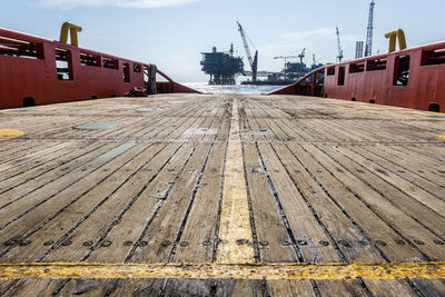 Deck of an anchor handling tug boat overlooking a oil production platform at offshore oil field