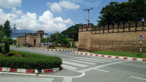 Street by buildings against sky in city