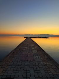 Scenic view of pier over lake during sunset