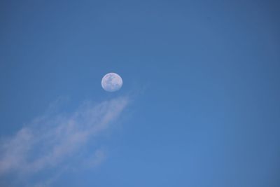 Low angle view of moon against clear blue sky