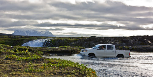 Pick up truck driving through stream on the icelandic highlands