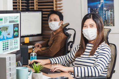 Portrait of business people wearing mask in office