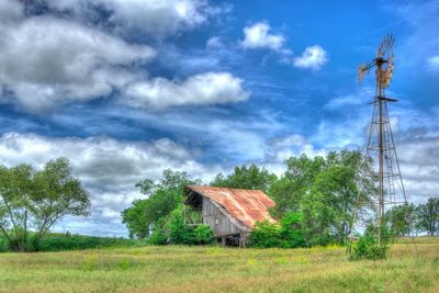 Rural landscape against cloudy sky