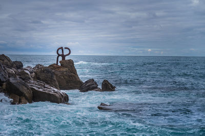 Scenic view of rocks in sea against sky