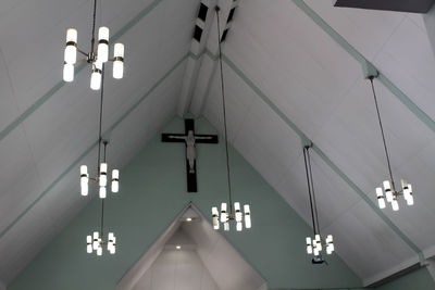 Low angle view of illuminated lights hanging on ceiling in building