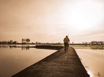 Rear view of man walking on pier