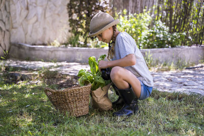 Side view of girl sitting on wicker basket