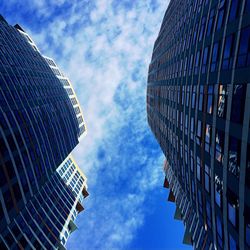 Low angle view of modern building against cloudy sky