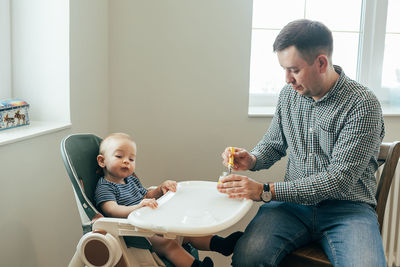 Side view of mother and daughter sitting at home
