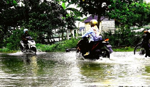 People riding horse in water