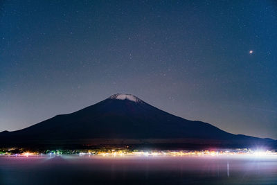 Scenic view of illuminated mountains against sky at night