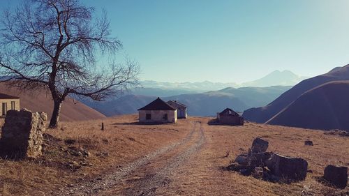 Houses by trees and mountains against sky