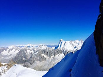 Scenic view of snowcapped mountains against clear blue sky