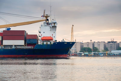 Ship moored at harbor against sky