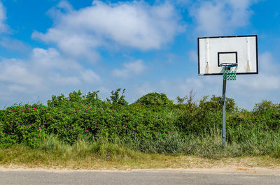 Old lonely basketball basket on the roadside, blue sky
