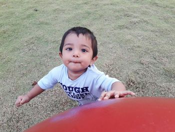 Portrait of cute boy playing on grass