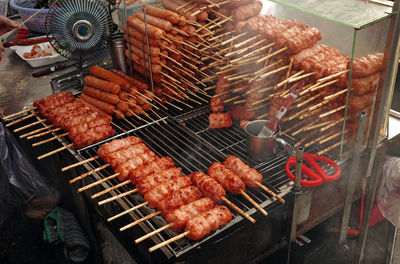 Grilled pork sausage on charcoal. nem nuong ninh hoa on street of hi chi minh city, viet nam.