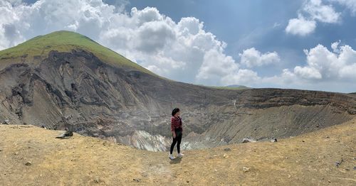 View of woman standing on mountain against sky