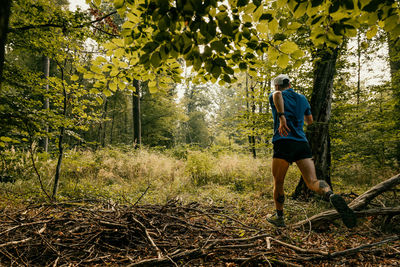 Young man jogging around a lake and the forest on an sunny autumn morning. long distance running.