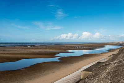 Scenic view of beach against blue sky