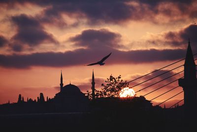 Low angle view of silhouette buildings against sky at sunset