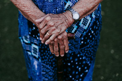 Midsection of senior woman holding walking cane