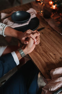 High angle view of man holding hands on table