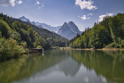 Scenic view of lake by trees against sky